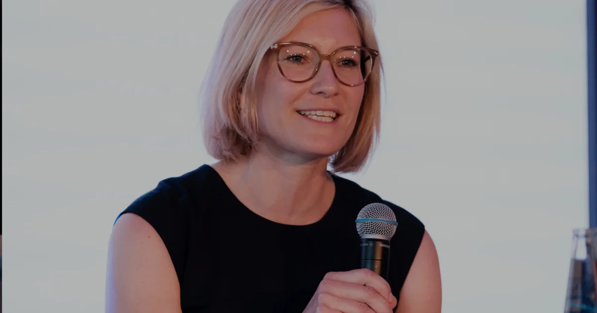 Sally Schulze mit Mikrofon bei einer Podiumsdiskussion